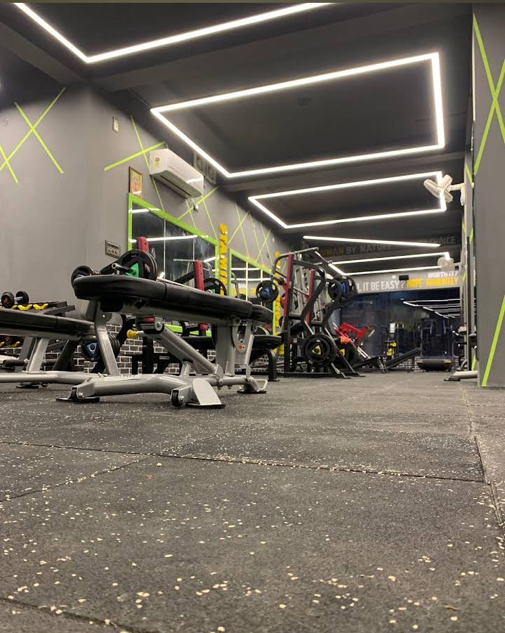 Sweatbox Gym weight bench area with neon X accents